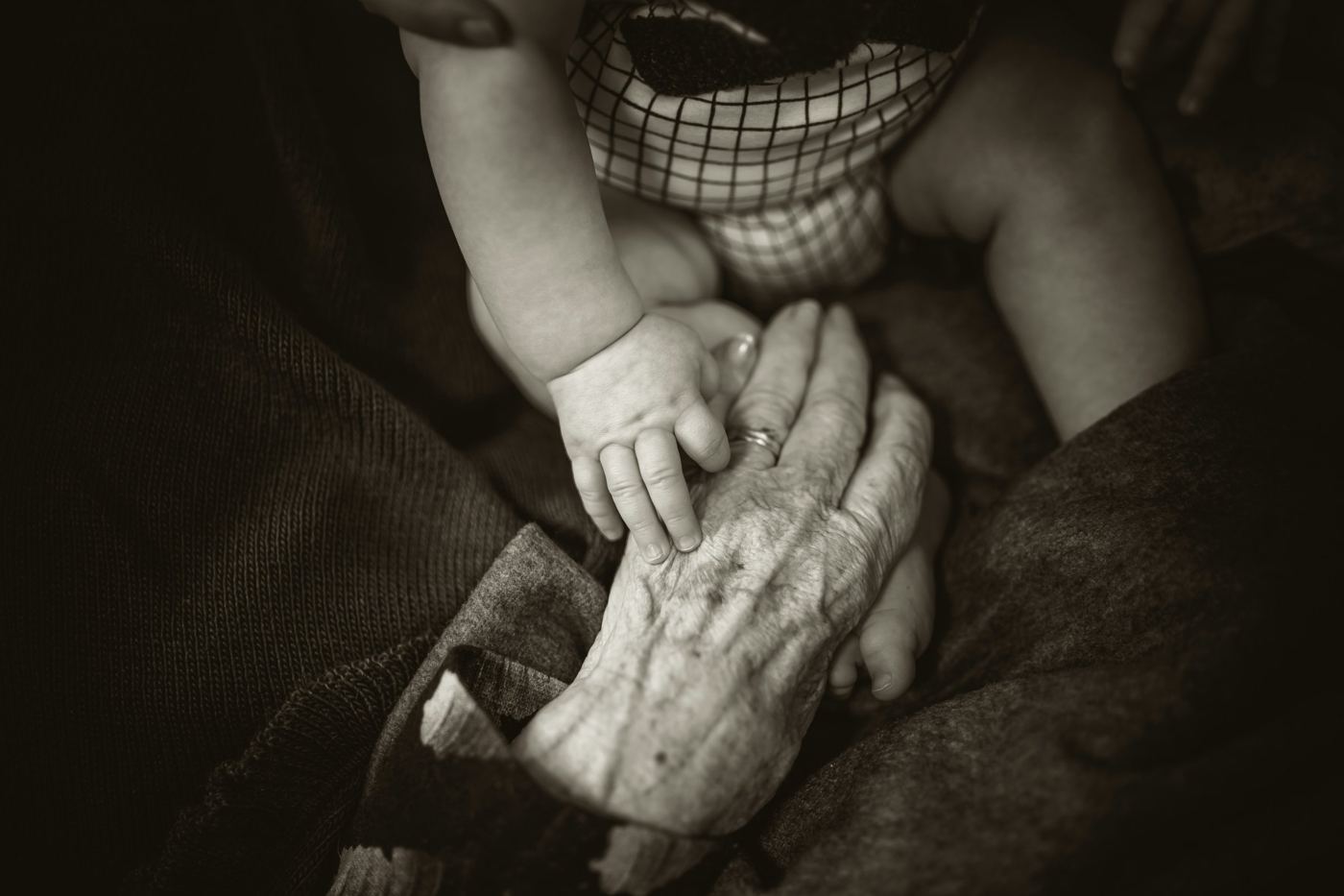 A baby's hand resting on an older person's hand